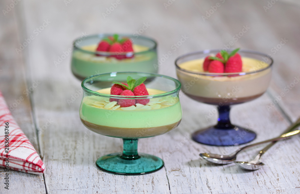 European dessert, national cuisine. Caramel Cream Mousse served with raspberries and mint in a glass European dessert, national cuisine. Caramel Cream Mousse served with raspberries and mint in a glass