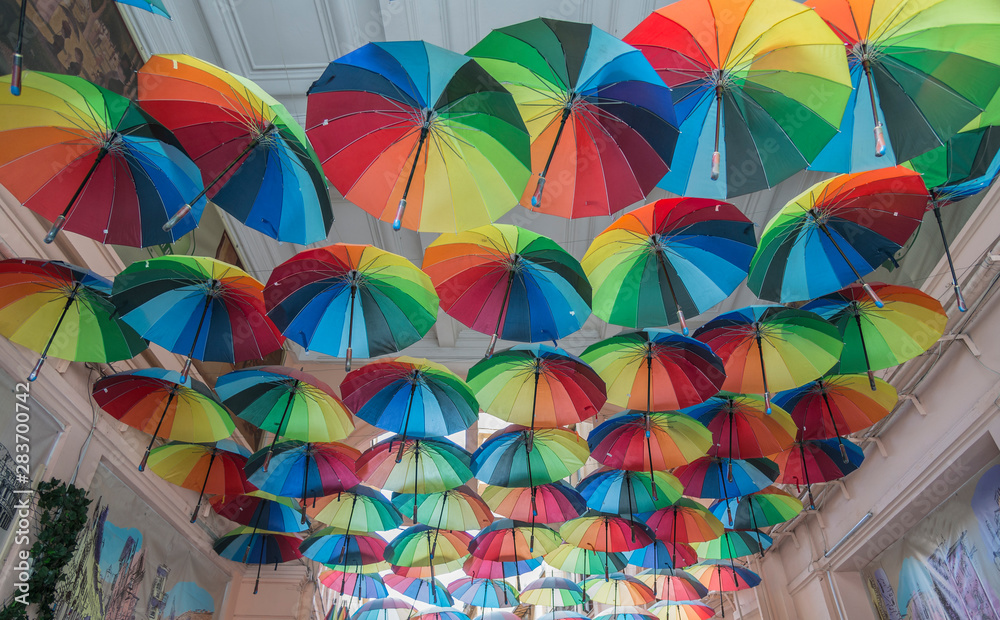 Fototapeta premium A small street in Bucharest covered by colorful umbrellas or parasols.