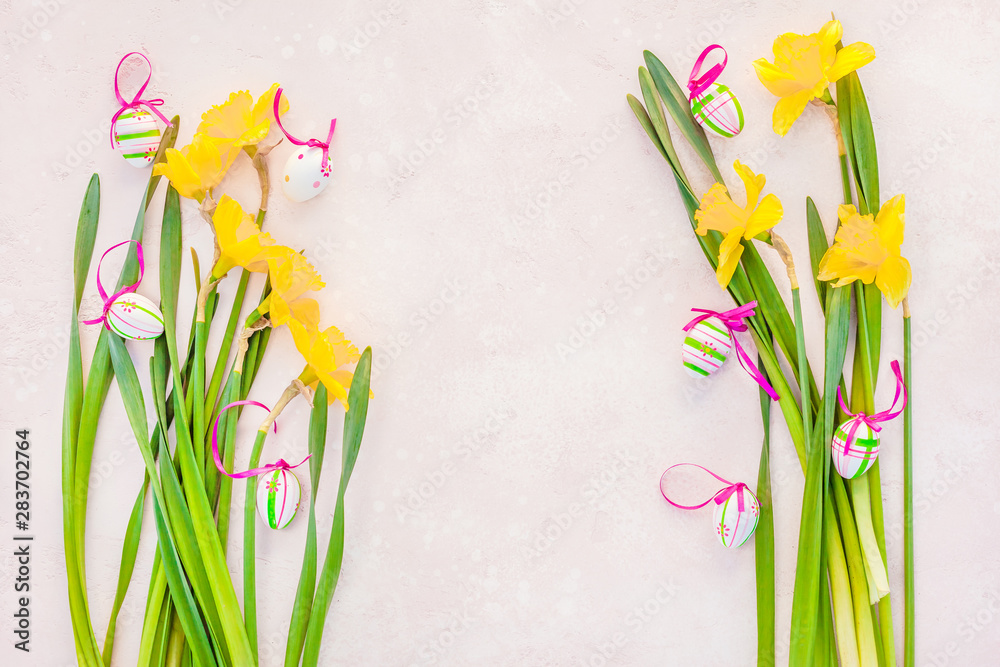 Yellow daffodil and easter eggs on pink background