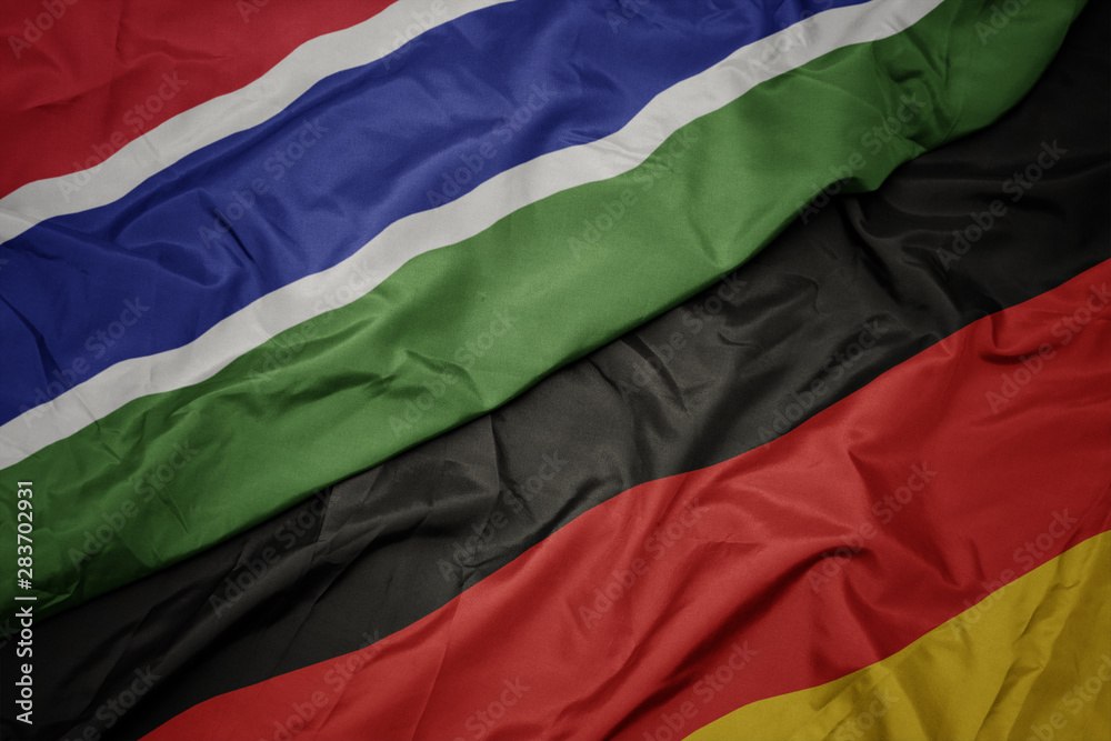 waving colorful flag of germany and national flag of gambia. waving colorful flag of germany and national flag of gambia.