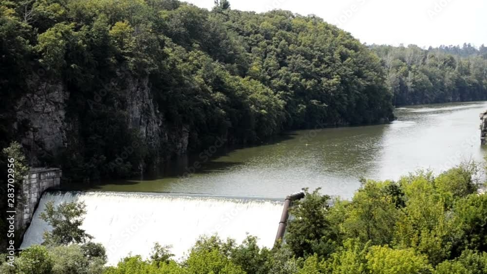 Dam with water overflow. The turbulent water. Dam water release because the excess capacity of the dam until spring-way overflows. Drainage of the dam Dam with water overflow. The turbulent water. Dam water release because the excess capacity of the dam until spring-way overflows. Drainage of the dam