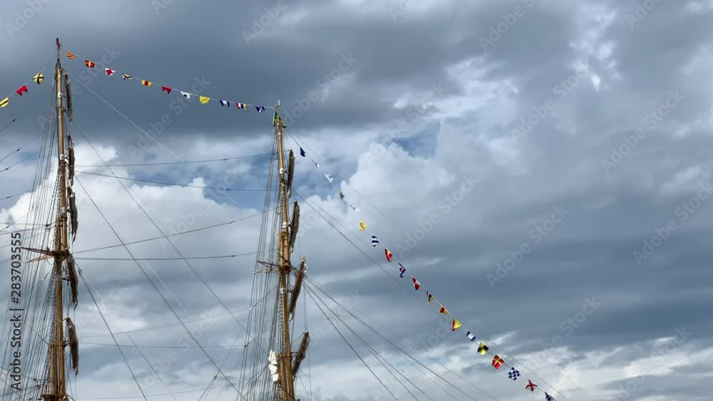 Rigging and masts of a big sailing ship with small flags in front of a ...