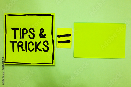 Word writing text Tips and Tricks. Business concept for Steps Lifehacks Handy advice Recommendations Skills Green paper notes reminders equal sign important messages to remember photo
