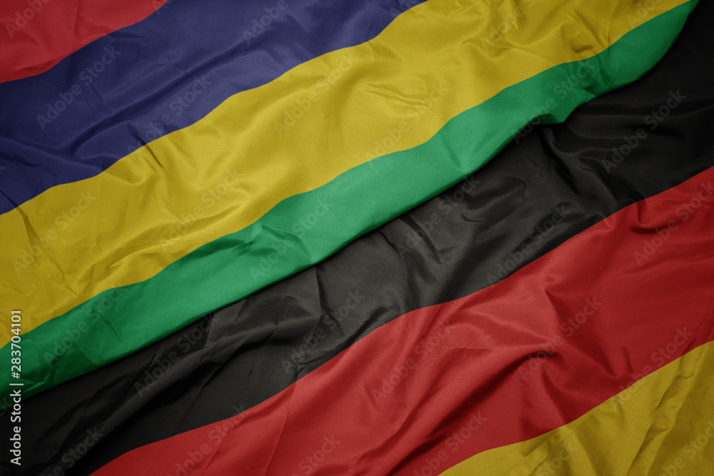 waving colorful flag of germany and national flag of mauritius. waving colorful flag of germany and national flag of mauritius.