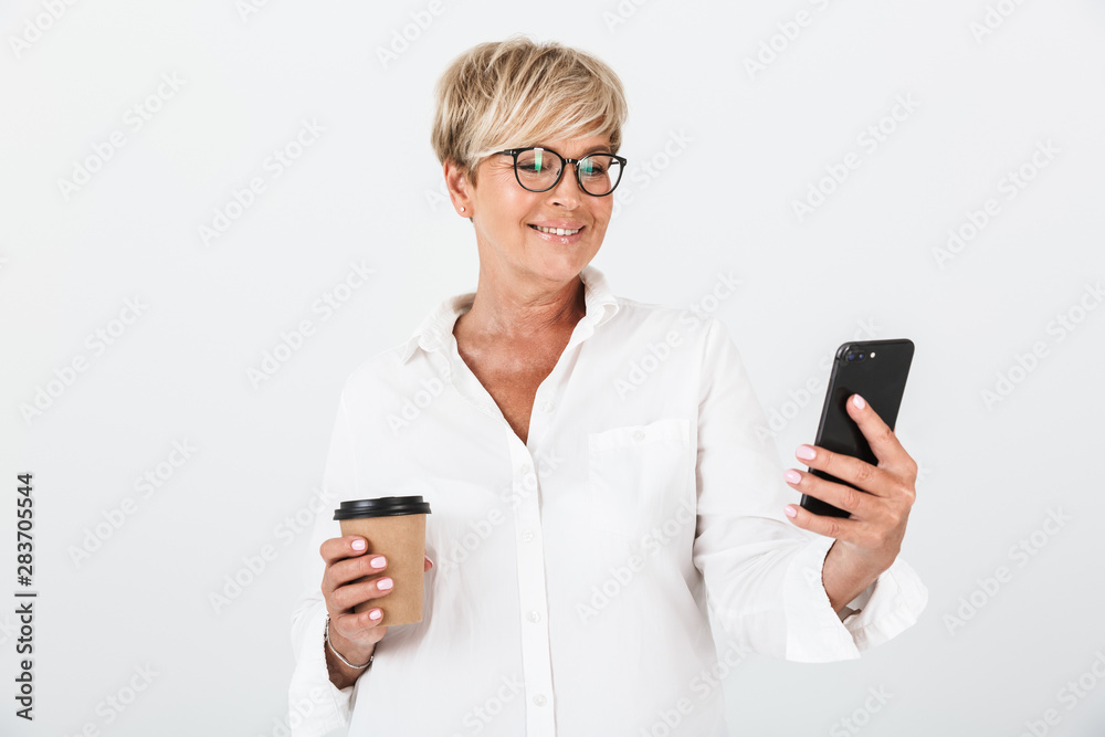 Portrait of smiling adult woman wearing eyeglasses holding cellphone and takeaway coffee cup Portrait of smiling adult woman wearing eyeglasses holding cellphone and takeaway coffee cup