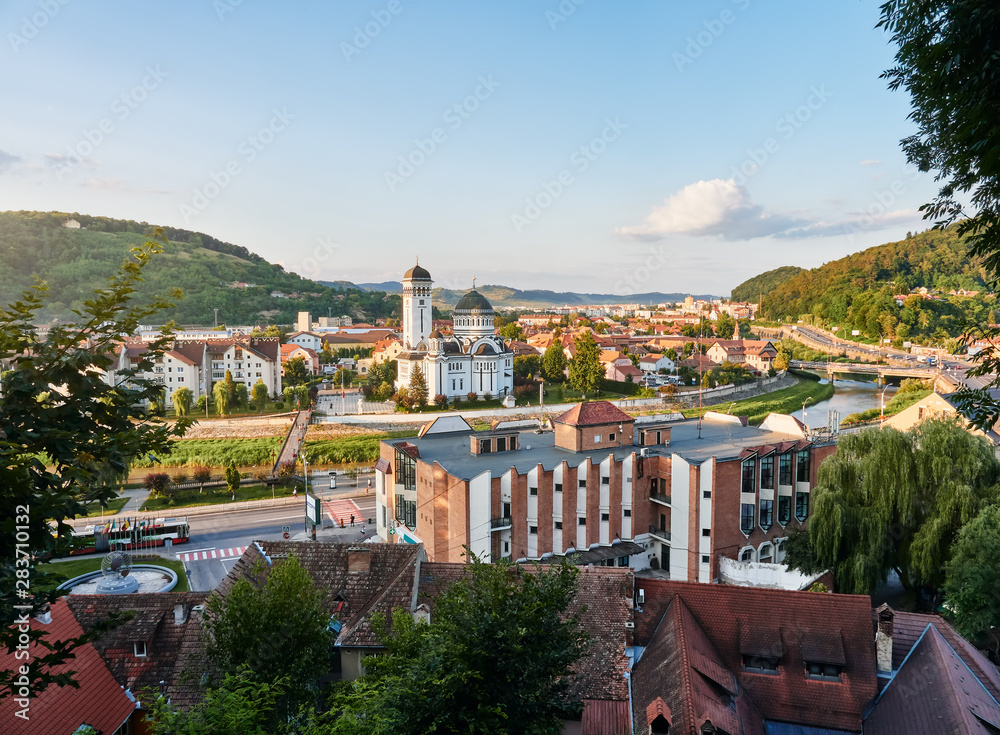 Aerial view of the city Sighisoara and its Orthodox Cathedral, Holy Trinity Church, at sunset in summer