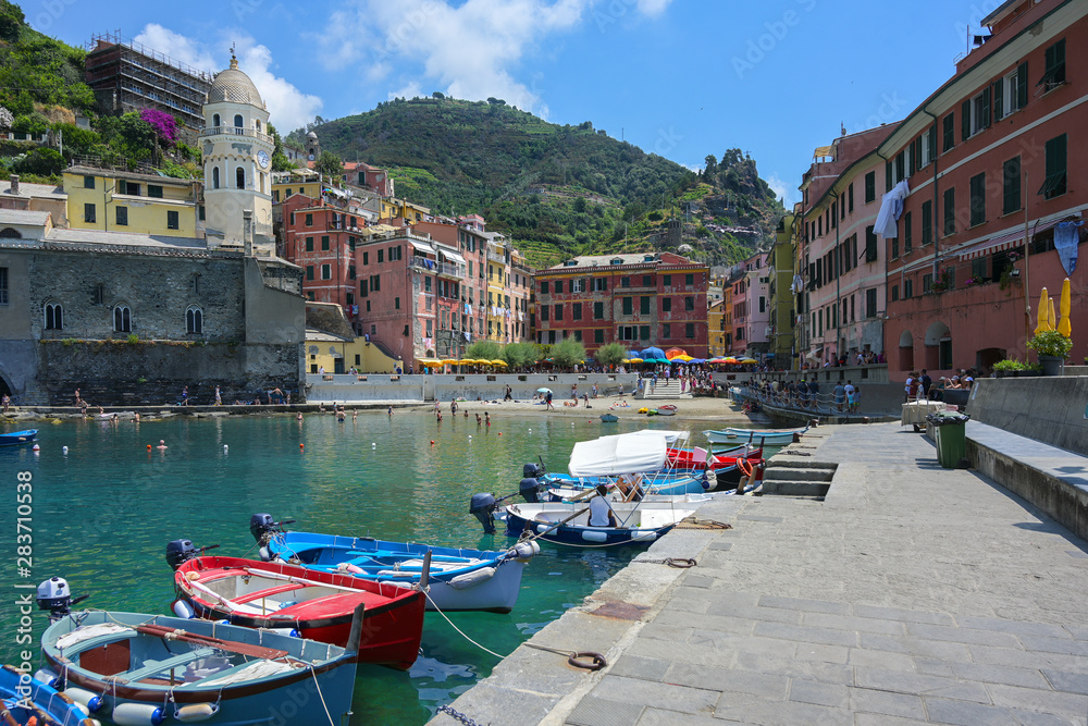 Boats in the harbor of Vernazza, one of the famous cinque terra mountain villages with colorful houses, tourist attraction on the Mediterranean sea coast in Liguria, Italy