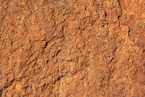 A fragment of the surface of a stone made of granite with a large grainy structure. Background, texture