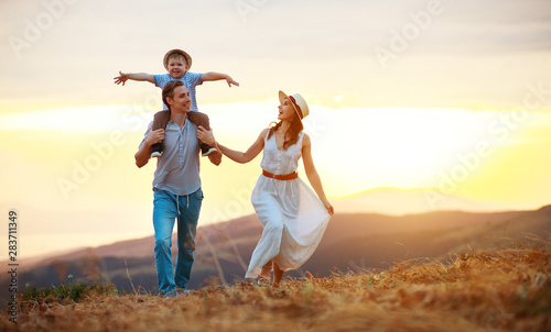 Happy family father of mother and child son on nature at sunset