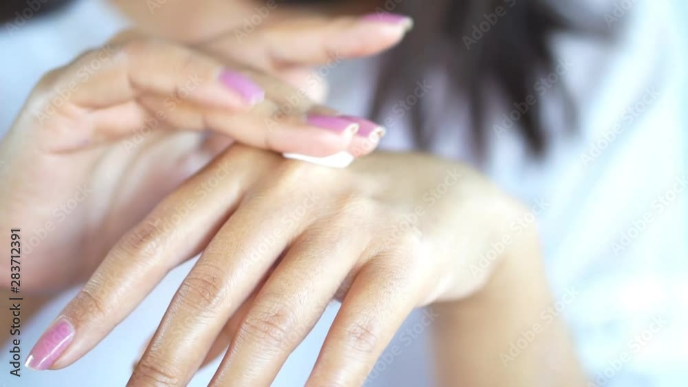 Asian woman applies cream on her beautiful hands closeup Asian woman applies cream on her beautiful hands closeup