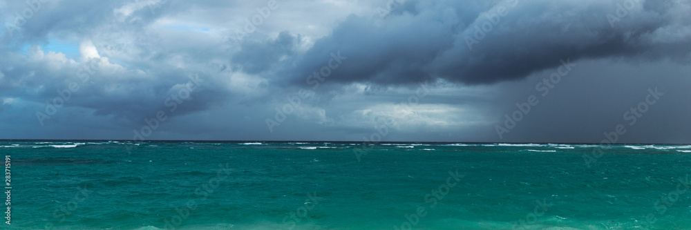Panoramic photo of the beginning of a storm on a wild ocean beac