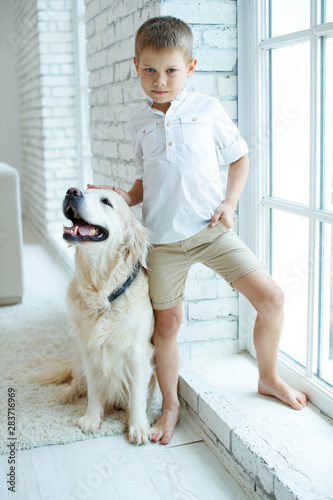 A child with a dog. Beautiful boy at home with a dog. 