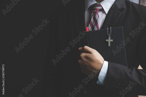 Fototapeta Naklejka Na Ścianę i Meble -  Man is holding and hug the bible in the morning. Hands folded in prayer on a Holy Bible in life concept. worship and religion. copy space