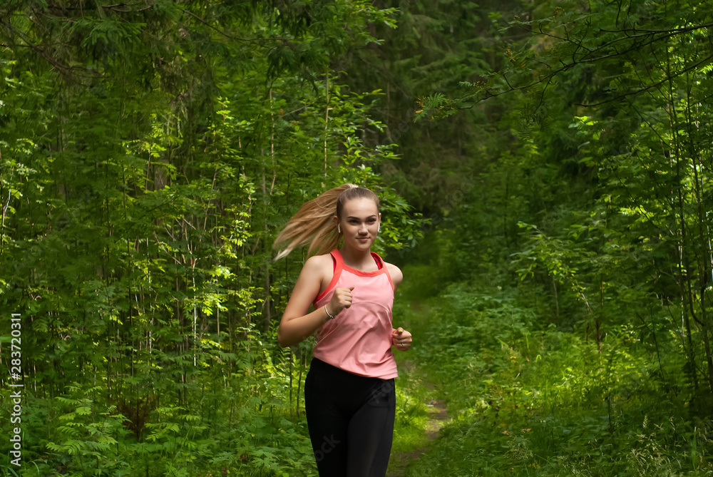 young woman jogging in sunny forest young woman jogging in sunny forest