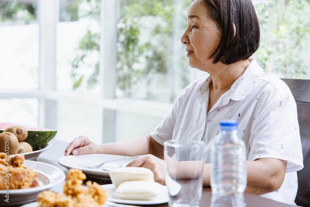 senior eating in dining room.Happy old woman eating food, smiling senior eating in dining room.Happy old woman eating food, smiling