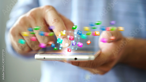 Hand using smartphone with social media icons