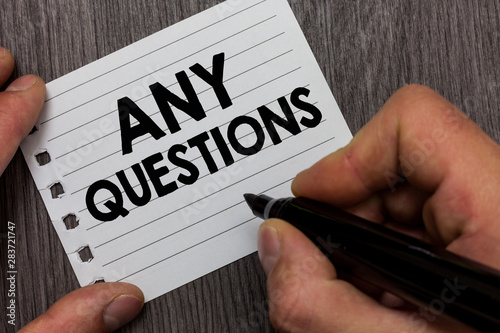 Conceptual hand writing showing Any Questions. Business photo showcasing Clueless Blank face Inquiry Disputes Probes Issues Riddles Man holding marker notebook page Wooden background photo