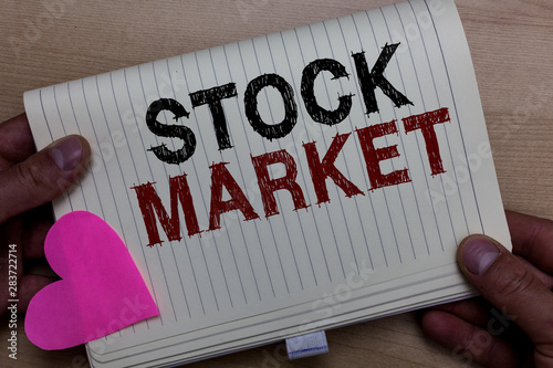 Word writing text Stock Market. Business concept for Particular market where stocks and bonds are traded or exhange Man holding notebook paper heart Romantic ideas messages Wooden background photo