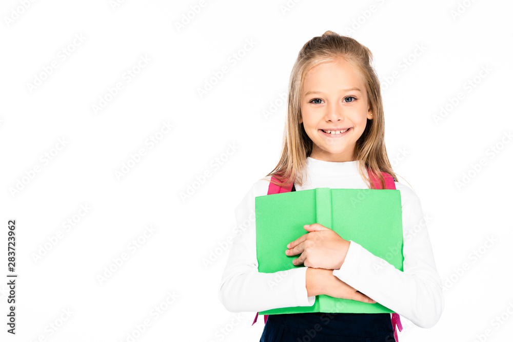 adorable, cheerful schoolgirl holding book and smiling at camera isolated on white adorable, cheerful schoolgirl holding book and smiling at camera isolated on white