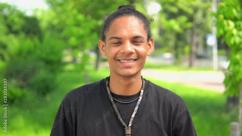 young man mixed race looking at the camera cheerful smiling handsome student posing outdoors young man mixed race looking at the camera cheerful smiling handsome student posing outdoors