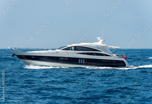 White and blue luxury yacht in motion on the Mediterranean sea, side view, Liguria, Italy, Europe