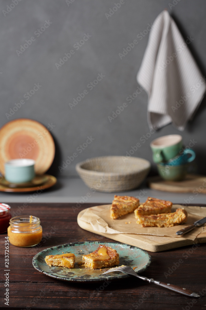 Cheddar shortbread cheesecake, cheddar pie and peach sauce on wooden table.