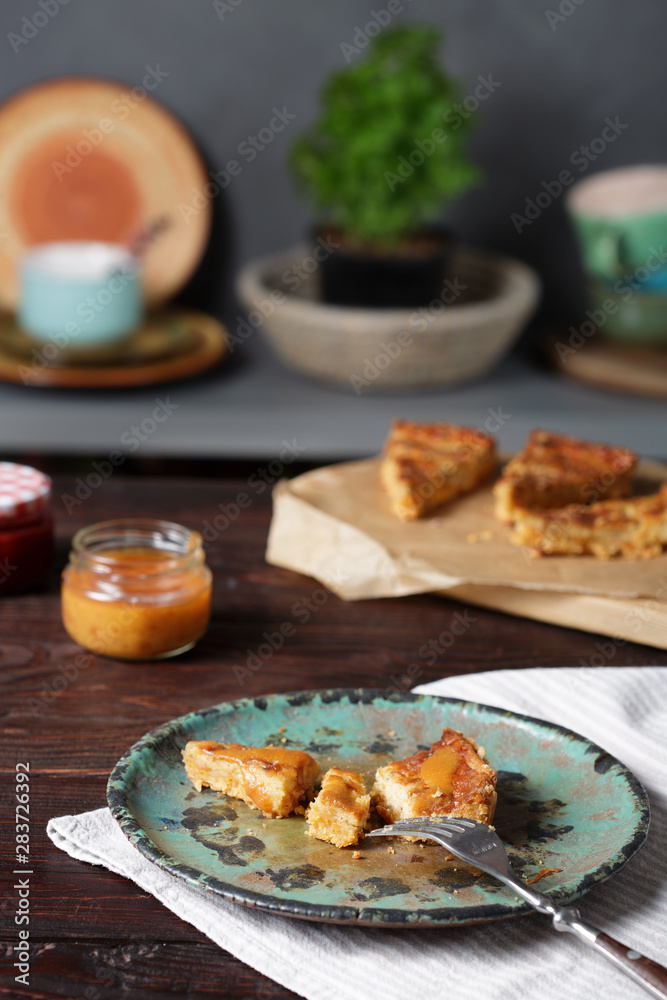 Cheddar shortbread cheesecake, cheddar pie and peach sauce on wooden table.