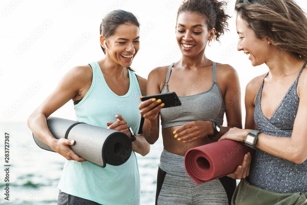 © Drobot Dean - Three cheerful young sport girls standing at the beach © Drobot Dean - Three cheerful young sport girls standing at the beach