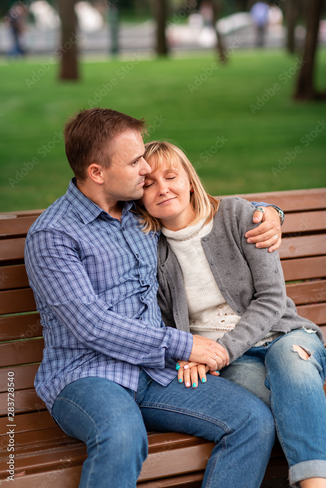 Happy young couple hugging and laughing together in the park