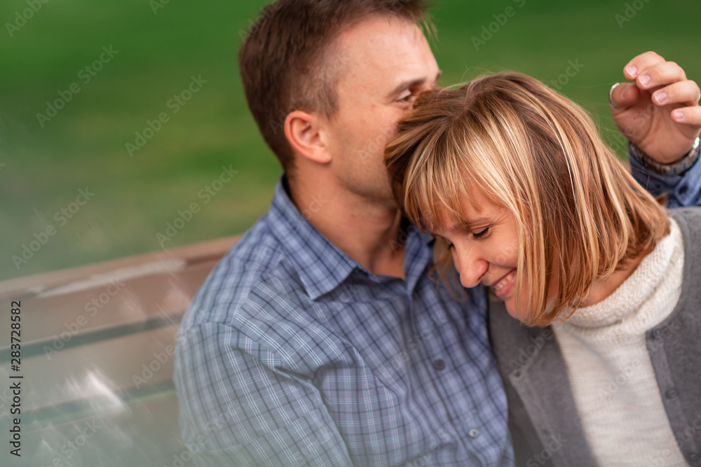 Happy young couple hugging and laughing together in the park Happy young couple hugging and laughing together in the park