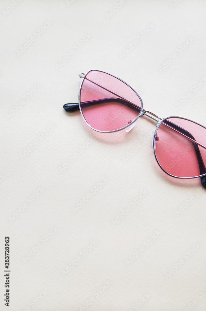 Pink sunglasses on beige paper background. Warm colors and shades Pink sunglasses on beige paper background. Warm colors and shades