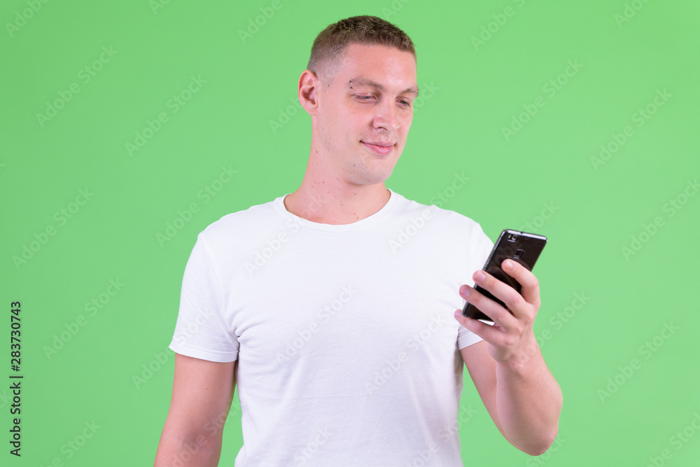 Studio shot of young man using phone Studio shot of young man using phone