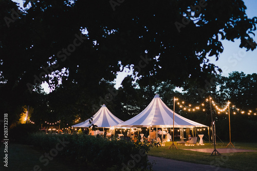 Coziness and style. Modern event design. Lounge zone and wedding reception decorations outdoors in the evening.
