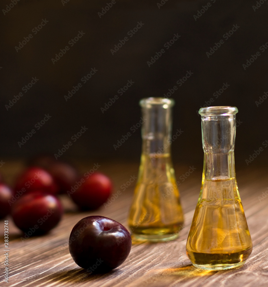 Rakia, rakia, fruit brandy drink and plums on wooden background