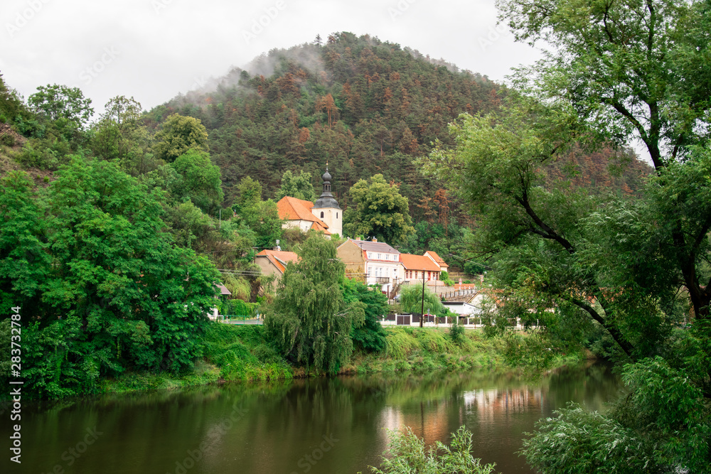 Ancient church by the river in mountainous countryside on a cloudy day