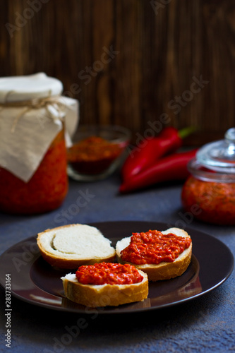 ajvar, appetizer of baked peppers on the table, bread with ajvar, toast with ajvar, balkan appetizer of baked peppers, vertical, space for your text