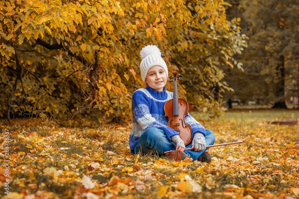 Child girl with a violin in the autumn Park Child girl with a violin in the autumn Park