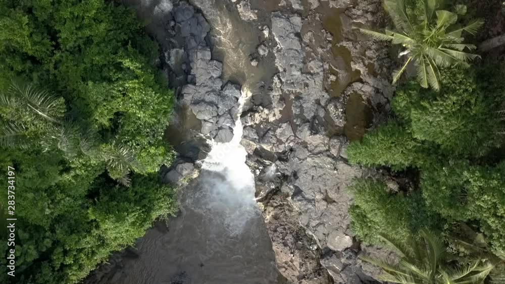 AERIAL OVERHEAD WATERFALL, Tegenungan in Bali, Indonesian. Surrounding by forest. AERIAL OVERHEAD WATERFALL, Tegenungan in Bali, Indonesian. Surrounding by forest.