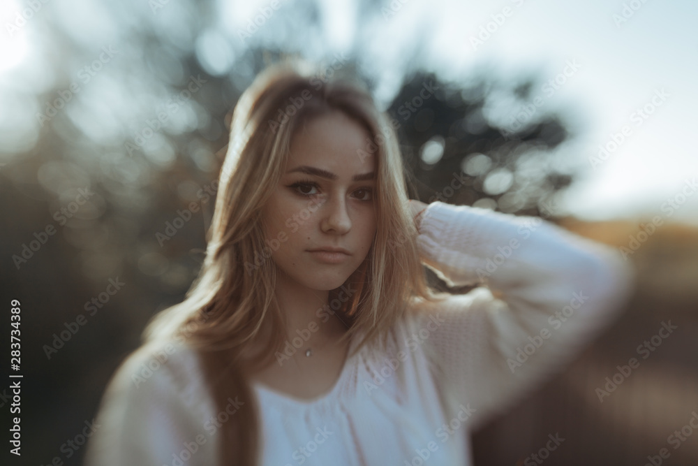 Portrait of pretty girl with defocused bushes in background