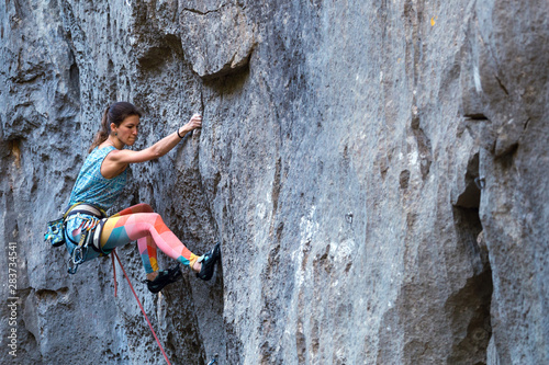 Fototapeta Naklejka Na Ścianę i Meble -  A girl climbs a rock.