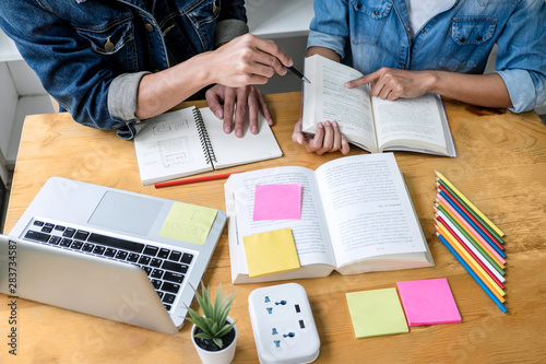 Education, teaching, learning concept. High school students or classmates group tutor in library studying and reading with helps friend doing homework and lesson practice preparing exam to entrance