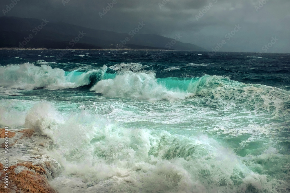 Stormy sea view  near coastline at evening time. Waves, splashed