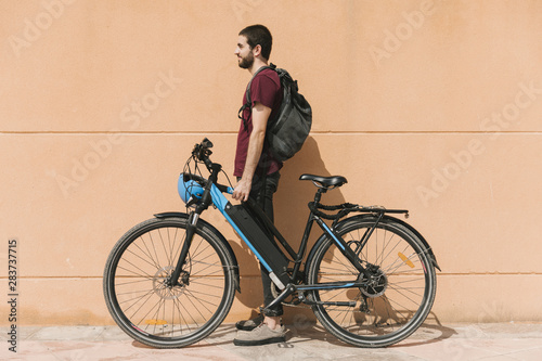 Urban cyclist standing next to e-bike