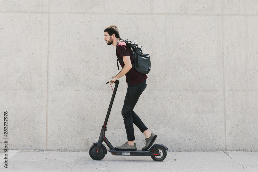Sideways man riding e-scooter Sideways man riding e-scooter