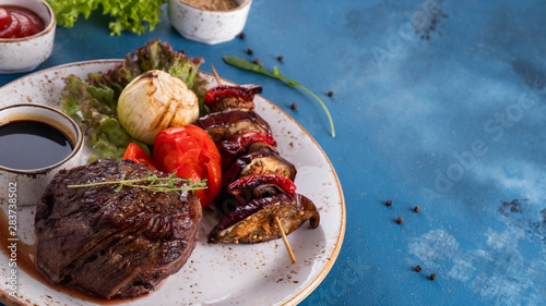 Medium rare  beef steak with herbs and grilled vegetables. Copy space photo