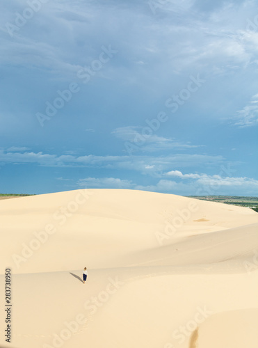 Female silhouette walking in desert sand dunes of Mui Ne, Vietnam