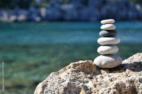 Stones balance on beach. Day and sun. 