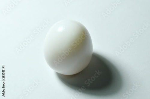 boiled hen egg with shadow on white background