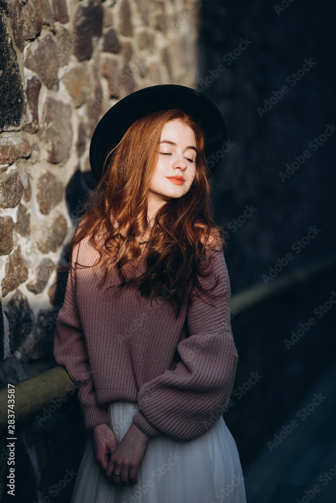 portrait of young woman in front of brick wall
