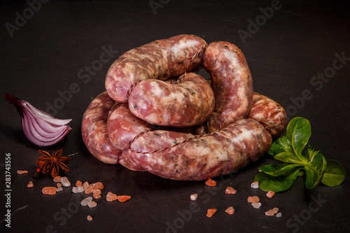 small heap of raw sausages grill with onion and basil